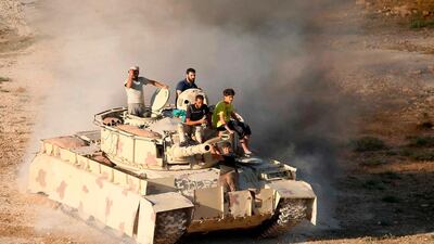 Syrian rebel fighters ride a tank in Daraa, southwestern Syria, on June 23, 2018. Mohamad Abazeed / AFP