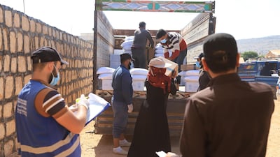 A woman receives aid from the World Food Programme at a camp for internally displaced people in Syria. All photos: Abd Almajed Alkarh for The National