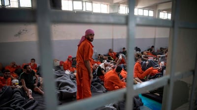 Men, allegedly affiliated with the ISIS, sit on the floor in a Kurdish prison in the north-east Syrian. AFP