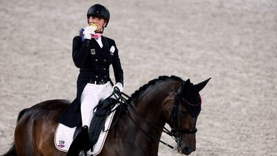 Germany's Jessica von Bredow-Werndl rides TSF Dalera as she kisses her dressage gold medal.
