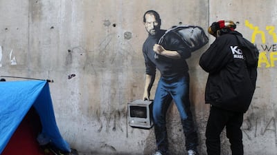 Banksy painted Apple founder Steve Jobs at the entrance of the Calais migrant camp in December 2015. AP