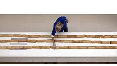 A volunteer straightens a section of the world's longest line of sandwiches at Dubai Outlet Mall yesterday.