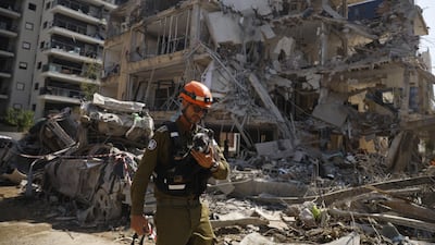 An emergency worker carries a rescued dog from a building damaged in an overnight strike on June 14, in Ramat Gan, Israel. Getty