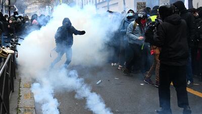 A protester, surrounded by smoke of tear gas, gestures during a demonstration for 'social rights' and against the 'global security' draft law, which Article 24 would criminalise the publication of images of on-duty police officers with the intent of harming their 'physical or psychological integrity', in Paris. AFP