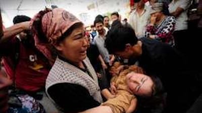 A Uighur woman is carried away after fainting during a protest in Urumchi yesterday. Authorities are blaming the unrest on international separatist groups.