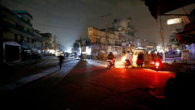 People are silhouetted on vehicle headlights on a dark street during widespread power outages in Rawalpindi, Pakistan. Pakistan's national power grid experienced a major breakdown late night on Saturday, leaving millions of people in darkness, local media reported. AP Photo