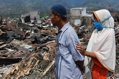 Tahir, 57, and his wife, who are from another district that suffered liquefaction from the earthquake, look over the devastation in the hard-hit area of Balaroa in Palu. AFP