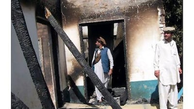 Tribesmen inspect a burnt-out school after an attack by Taliban in the northwestern district of Upper Dir on June 3, about six kilometres from the border with Afghanistan.