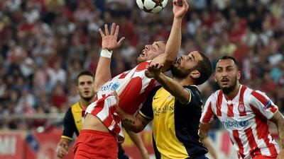 Olimpiakos' Pajdim Kasami, left, fights for the ball with Mario Suarez of Atletico Madrid during their Champions League match on Tuesday. Aris Messinis / AFP