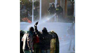 Police riot use water cannons against protesters in Davos after they turned violent. Jean-Christophe Bott / EPA