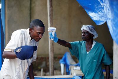 A health worker takes the temperature of a man entering an Ebola treatment centre in Beni, in the Democratic Republic of Congo in April, 2019. Reuters