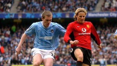 Del Manchester United Diego Forlán , a la derecha , se ve desafiada por la ciudad de Manchester Richard Dunne durante un partido de la Premier League en el Estadio Ciudad de Manchester en Manchester el 14 de marzo de 2004. Paul Barker / AFP