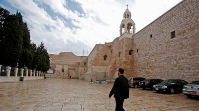 A priest walks past the Church of the Nativity in the West Bank city of Bethlehem, a day after spraying sanitizers as a preventive measure against the coronavirus. AFP