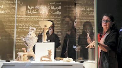 Sophie Mery, the guest curator of the exhibition, with some of the artifacts on display. Pawan Singh / The National