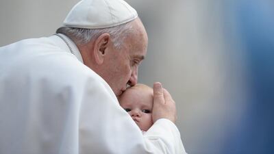 Pope Francis kisses a baby as he arrives for his weekly general audience at St Peter’s square at the Vatican. Filippo Monteforte / AFP Photo