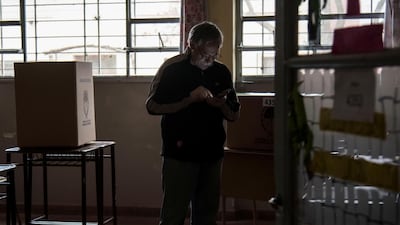 A man looks at his phone before casting a vote at a polling station during a national blackout, in Rosario, Santa Fe, Argentina. Reuters