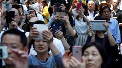 Voters using smart phones take photos of Tokyo governor and head of Tokyo Citizens First party Yuriko Koike (not in picture) as she delivers a speech to voters as election campaign officially kicks off for Tokyo Metropolitan Assembly election, on the street in Tokyo in June. Issei Kato / Reuters
