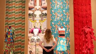 An employee poses as she views various designs which form part of the "REBEL: 30 Years of London Fashion" exhibition at the Design Museum in London, Britain September 11, 2023. REUTERS / Toby Melville
