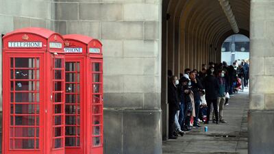 Members of the public wait for a dose of a Covid-19 vaccine, as they queue outside Manchester Town Hall.