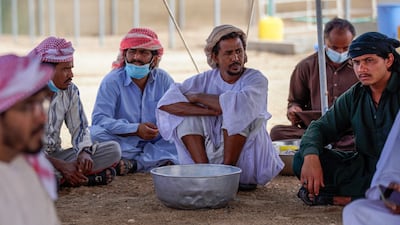 Camel farmers wait in a tent before the festival gates open.
