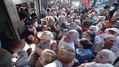Pensioners queue outside a bank branch to withdraw €120, the maximum amount they were allowed to take by the finance ministry. Louisa Gouliamaki / AFP