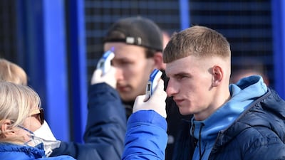 A fan passes the security control and has his temperature check as he arrives to attend the Belarus Championship football match. AFP