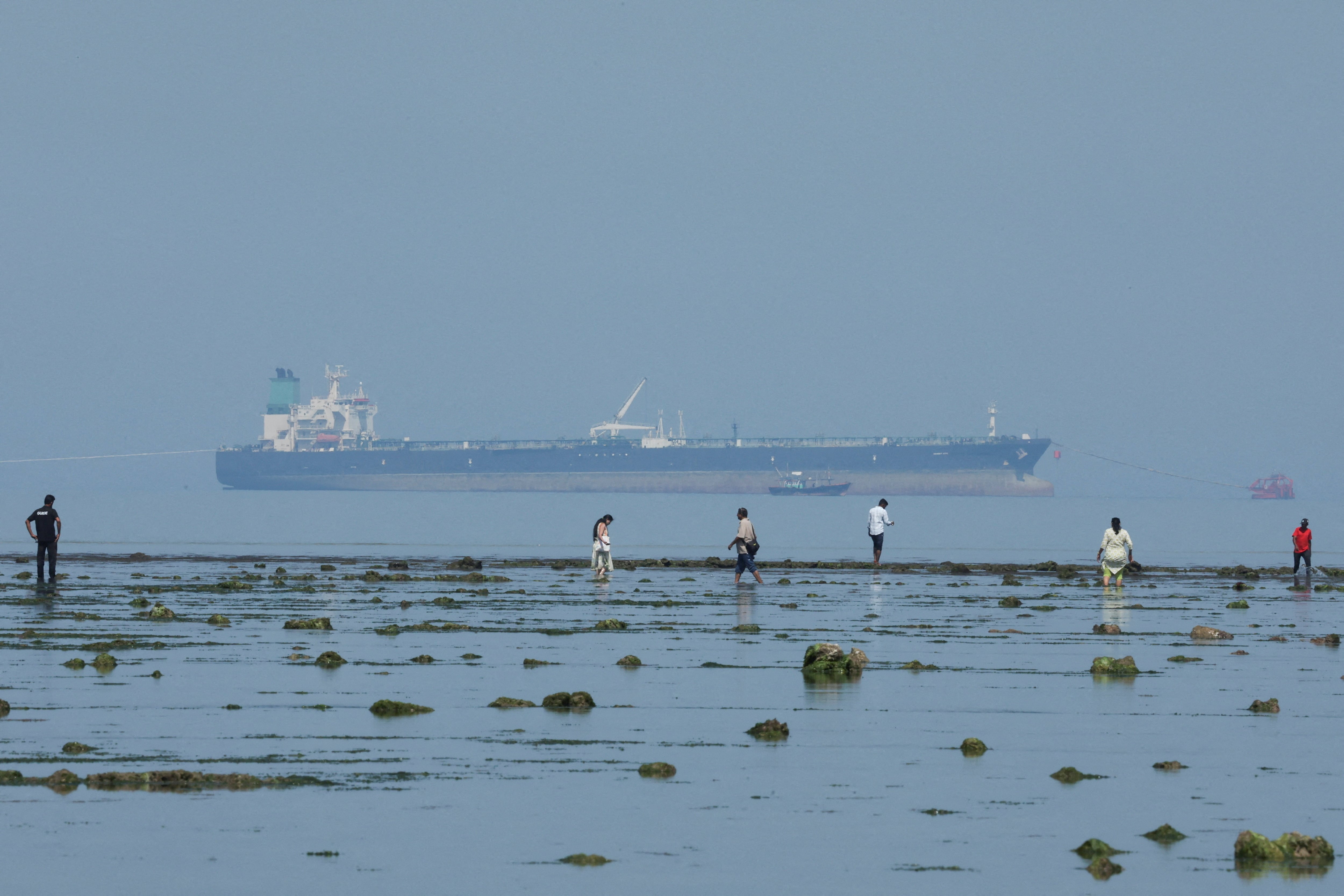 Tourists watch marine life, with the MT Desert Kite oil tanker carrying Russian oil in the background, at Narara Marine National Park in the Arabian Sea, Gujarat, India. REUTERS