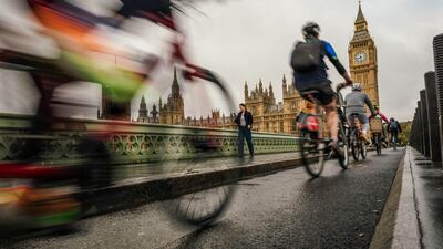 Cyclists cross Westminster Bridge, near Britain's Houses of Parliament, in central London. Bloomberg