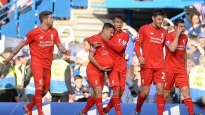 Philippe Coutinho celebrates with teammates after scoring the first goal for Liverpool against Chelsea on Saturday. Philip Brown / Reuters