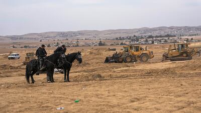 Israeli security forces stand guard during a protest held by Bedouins against tree-planting by the Jewish National Fund on disputed land near the village, which is in the Negev desert, in southern Israel. AP