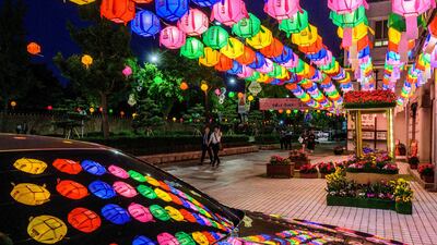 Pedestrians walk past a display of lotus lanterns outside the Beomnyeonsa Temple in Seoul. AFP