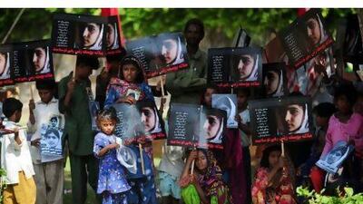 Pakistani flood affected victims carry photographs of child activist Malala Yousafzai to mark the "Malala Day" in Karachi.
