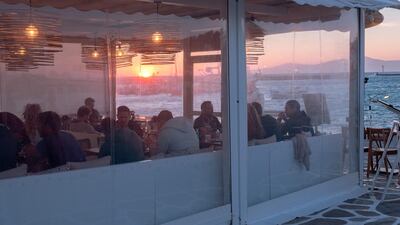 Customers dine at a recently reopened restaurant in the Old Port of Mykonos. Photographer: Loulou D'Aki/Bloomberg