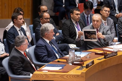 Algerian Ambassador to the UN Amar Bendjama shows a picture of a severely malnourished child to Israeli Foreign Minister Gideon Saar during a UN Security Council meeting in New York on Tuesday. EPA