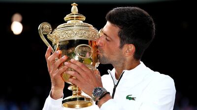 Novak Djokovic poses with the Wimbledon trophy after beating Roger Federer in Sunday's final. Getty Images