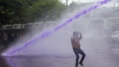 Police use colored water from a water canon to disperse Kashmiri government employees during a protest in Srinagar. Dar Yasin / AP Photo
