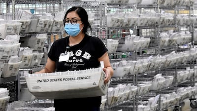 A worker carries ballots that are postmarked and mailed by the deadline on election day in Pomona, California. AP Photo