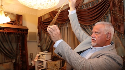 Shaukat holds up old negative films at his home in Dubai.