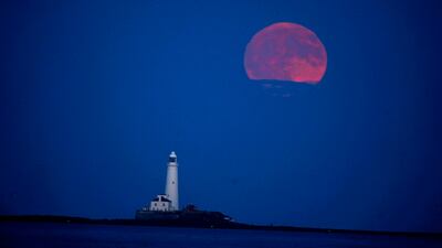 The full Moon, also known as the Strawberry Moon, rises over St Mary's Lighthouse in Whitley Bay, north-east England. AP