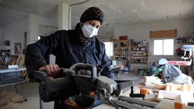 A Palestinian woman works at a carpentry shop in Al Walajah village, close to the West Bank city of Bethlehem. Five years ago, a group of housewives began recycling waste timber into usable products, which were sold to souvenir shops. AFP