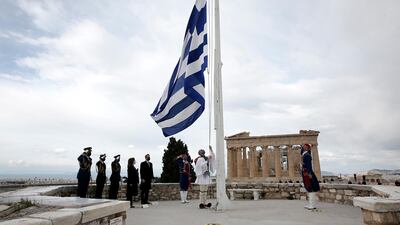 Greek Presidential Guards hoist the Greek flag in front of the Parthenon temple at Acropolis hill. EPA