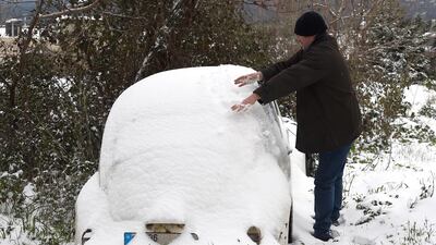 epa08205391 A man removes snow from the roof of his car after heavy snowfall in the village of Hammana southeast Beirut, Lebanon, 09 February 2020. According to the Lebanese meteorology, Lebanon has been affected by a rainstorm for several days, as snow-covered most mountain villages with a steep drop in temperature. EPA/WAEL HAMZEH