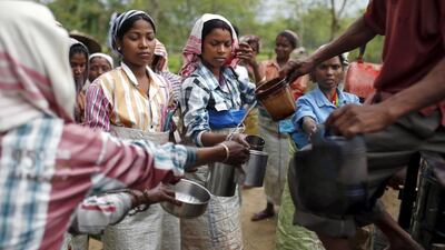 Workers collect drinking water during a break.