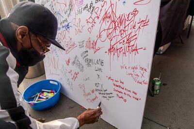 Ivey Bronson, 59, writes a note on a board for a Celebration of Life Memorial for rapper DMX at The Barclays Centre. AP photo