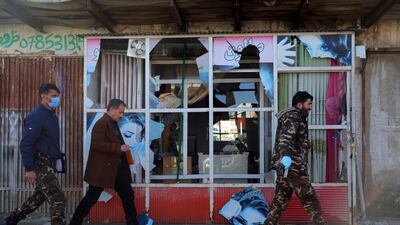 Afghan security personnel inspect a damaged shop after a mortar shell attack in Kabul. AP Photo