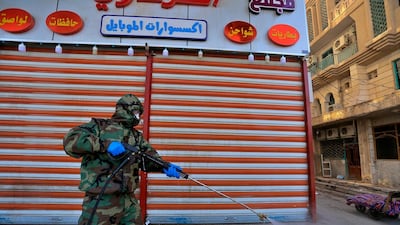 A Civil Defense member wearing protective suits sprays disinfectant as a precaution against the coronavirus in the closed shops, and hotels in Najaf, Iraq. AP