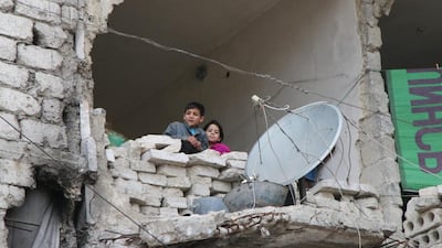Children peer from a partially destroyed home in Aleppo, Syria. Alexander Kots / Komsomolskaya Pravda via AP