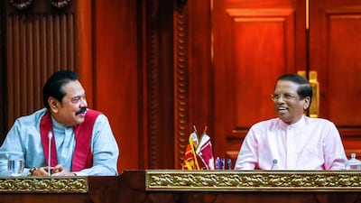 Sri Lanka's newly appointed prime minister Mahinda Rajapakse, left, smiles next to president Maithripala Sirisena during a party members' meeting on Saturday. Reuters