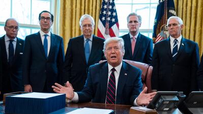 President Donald Trump signs the coronavirus stimulus relief package in the Oval Office at the White House. AP Photo/Evan Vucci