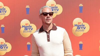 Diplo wearing a maroon-collared polo and wide-legged trousers. AFP